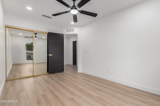 unfurnished bedroom with light wood-style floors, visible vents, a closet, and baseboards