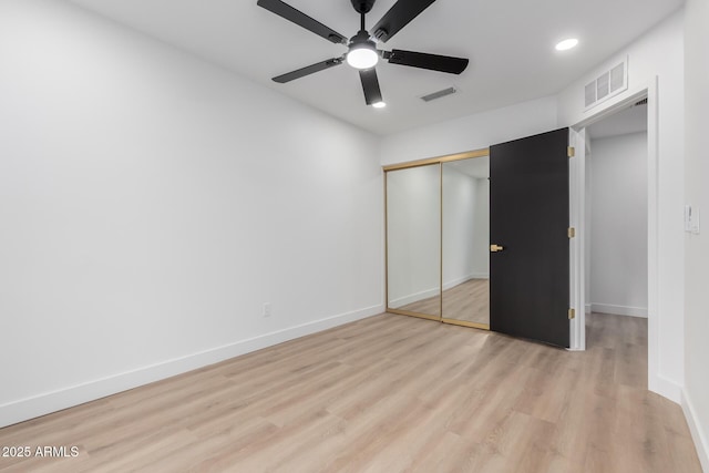 unfurnished bedroom featuring baseboards, visible vents, and light wood finished floors