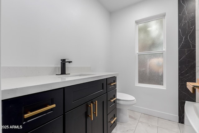 full bathroom with vanity, toilet, a bathtub, and baseboards