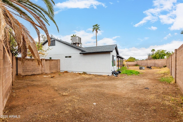 view of home's exterior with central air condition unit, a fenced backyard, roof with shingles, and stucco siding