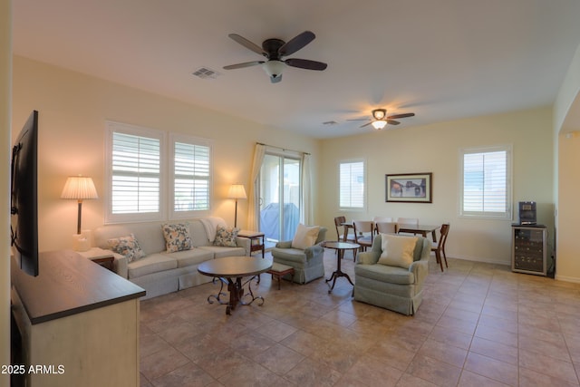 living room with a wealth of natural light, beverage cooler, ceiling fan, and light tile patterned floors