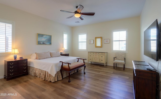 bedroom featuring multiple windows, wood-type flooring, and ceiling fan