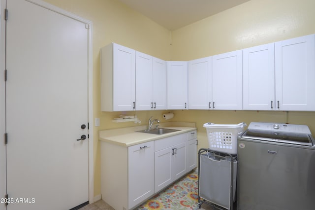 washroom with cabinets, washer / dryer, and sink