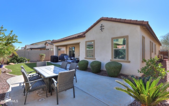 back of property featuring a patio and a lawn