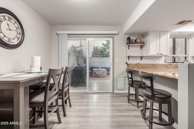 dining area with sink and light wood-type flooring