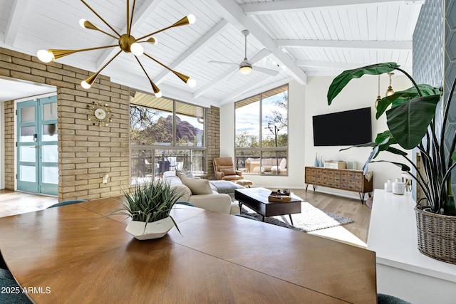 interior space with lofted ceiling with beams and ceiling fan