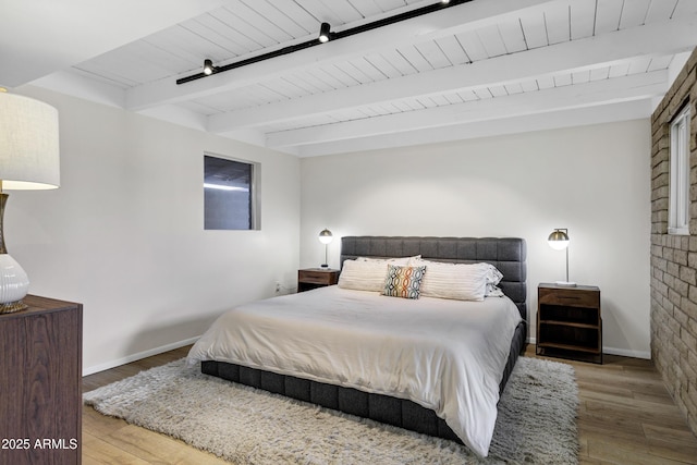 bedroom with hardwood / wood-style flooring, wooden ceiling, and beam ceiling