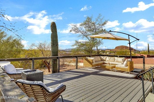 wooden deck featuring an outdoor living space with a fire pit