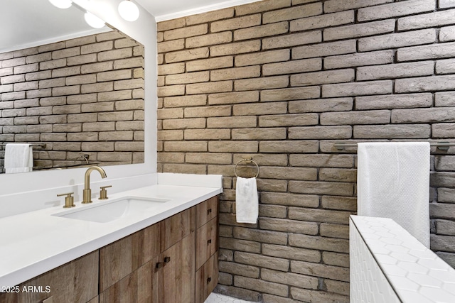 bathroom with vanity, brick wall, and crown molding