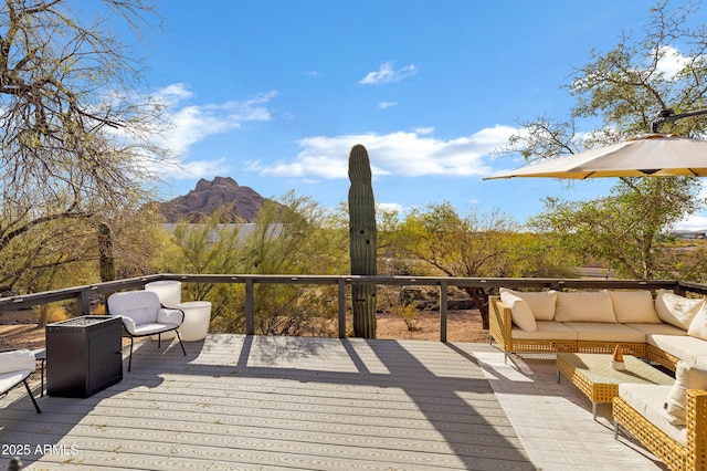 wooden terrace with an outdoor living space and a mountain view