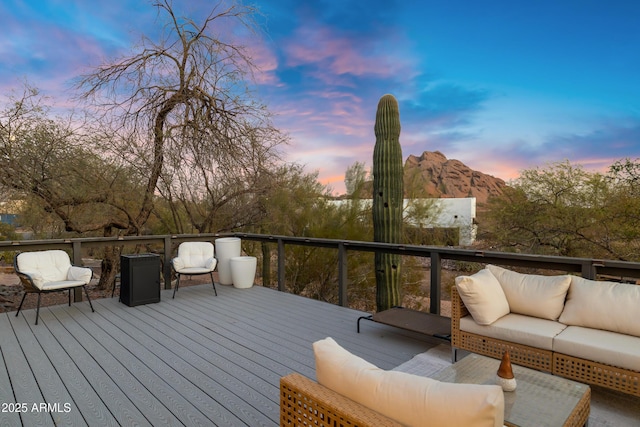 deck at dusk with a mountain view and an outdoor hangout area