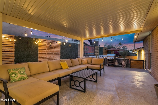 patio terrace at dusk with area for grilling and an outdoor hangout area