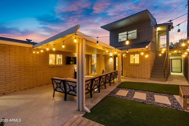 rear view of property featuring a yard, an outdoor hangout area, and a patio area