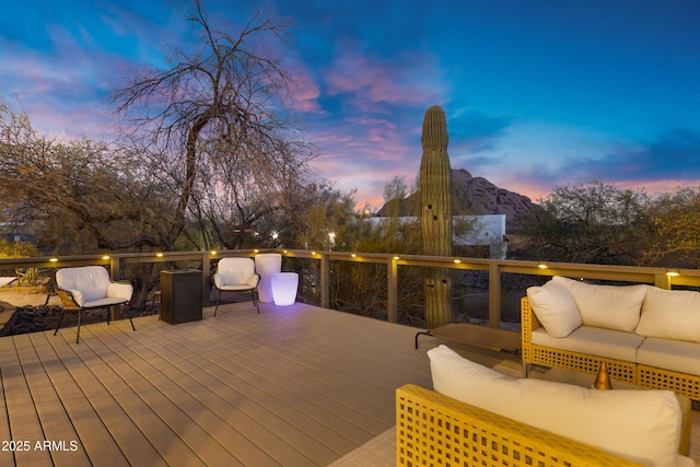 deck at dusk with an outdoor hangout area and a mountain view