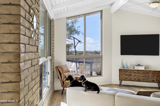 living room featuring vaulted ceiling with beams and light hardwood / wood-style floors