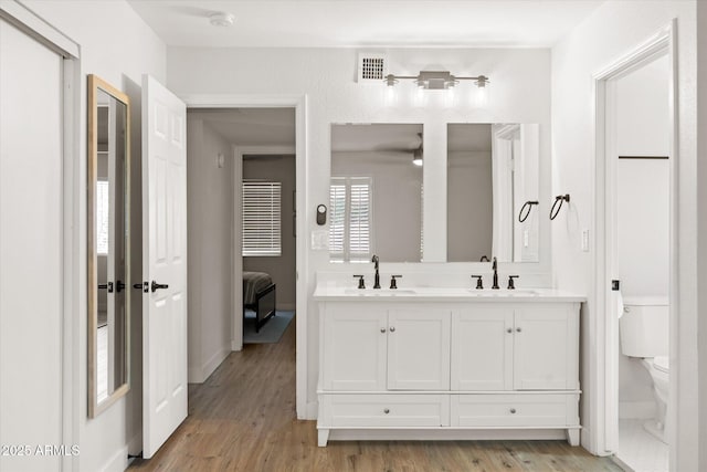 1800 W Shawnee Dr, Chandler, AZ 85224 - full bathroom with toilet, wood finished floors, double vanity, and baseboards