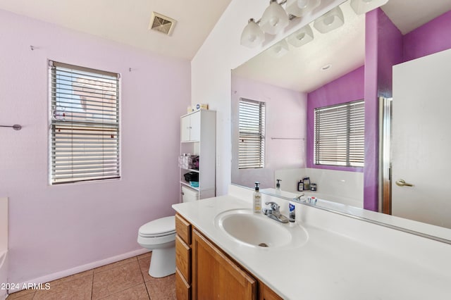 bathroom featuring a healthy amount of sunlight, vanity, vaulted ceiling, and toilet