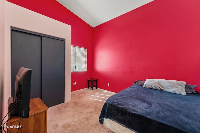 bedroom featuring a closet, light carpet, and vaulted ceiling