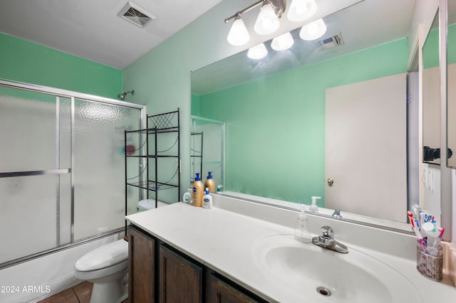 full bathroom featuring toilet, enclosed tub / shower combo, vanity, and tile patterned flooring