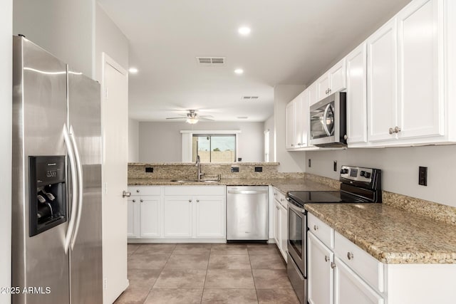 kitchen featuring a ceiling fan, visible vents, a sink, stainless steel appliances, and white cabinets