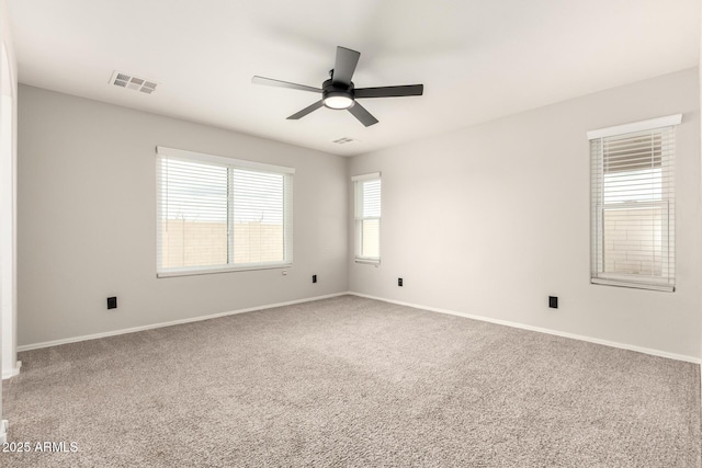 unfurnished room with visible vents, baseboards, carpet, and ceiling fan