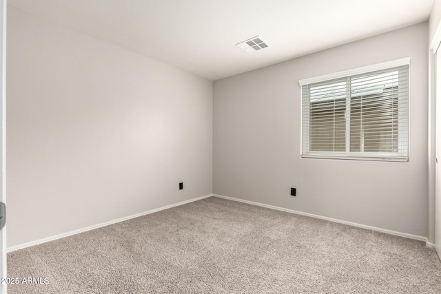 spare room featuring visible vents, carpet flooring, and baseboards