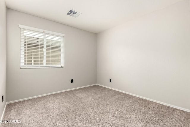 carpeted spare room featuring visible vents and baseboards