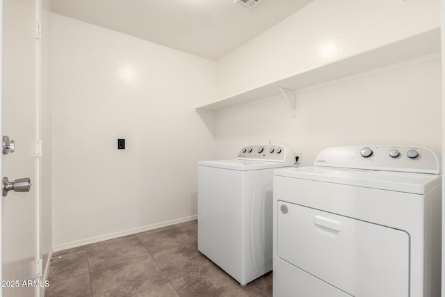 laundry room with washing machine and clothes dryer, visible vents, baseboards, light tile patterned floors, and laundry area