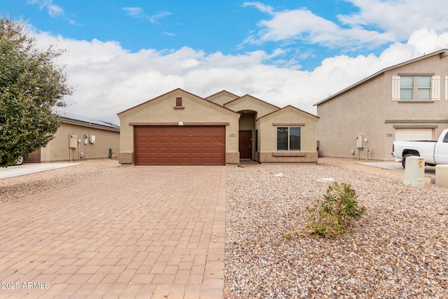 view of front of home with stucco siding, an attached garage, and decorative driveway