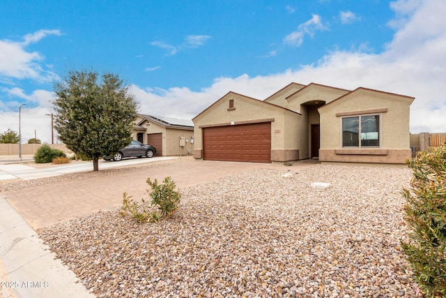 ranch-style house with concrete driveway, an attached garage, fence, and stucco siding