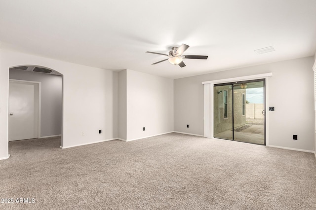 unfurnished room with visible vents, baseboards, carpet floors, arched walkways, and ceiling fan