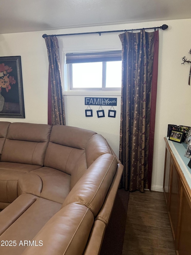 living area featuring baseboards and dark wood finished floors