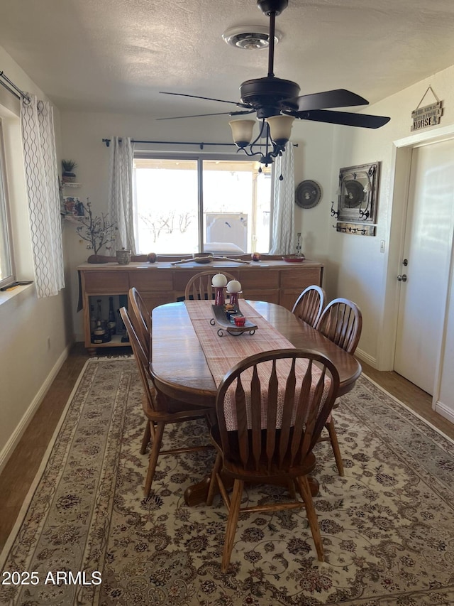 dining area with baseboards, a textured ceiling, ceiling fan, and visible vents