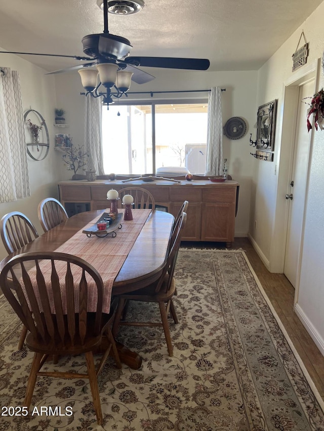 dining space featuring baseboards, ceiling fan, and wood finished floors