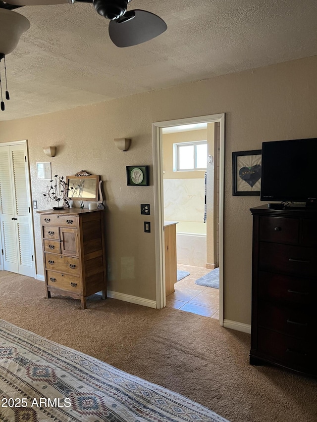 bedroom featuring carpet floors, a ceiling fan, a textured ceiling, and baseboards