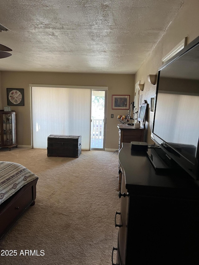 bedroom featuring access to outside, a textured ceiling, baseboards, and carpet