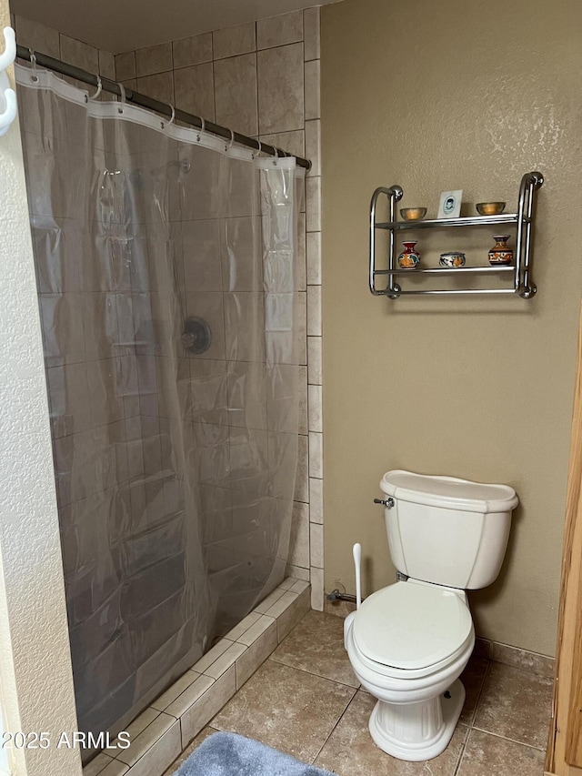 full bathroom featuring toilet, a shower stall, and tile patterned flooring