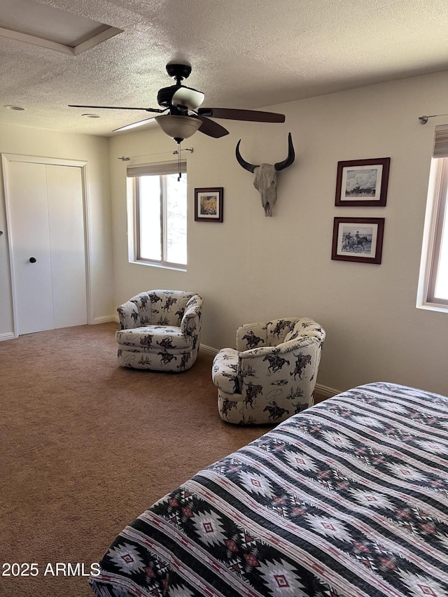 carpeted bedroom featuring baseboards, a textured ceiling, ceiling fan, and a closet