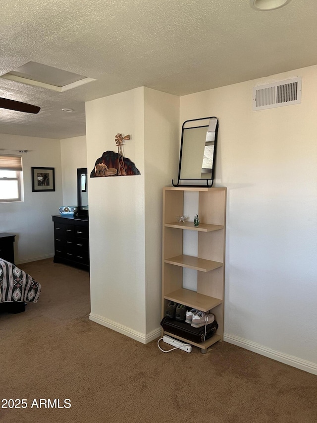 unfurnished bedroom featuring baseboards, carpet flooring, a textured ceiling, and visible vents