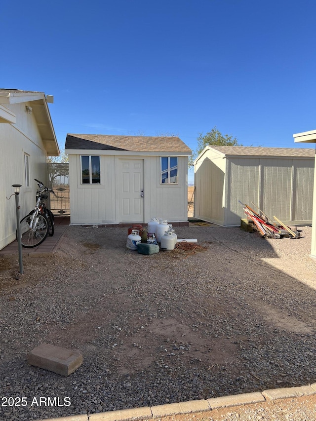 back of property featuring a storage unit and an outdoor structure