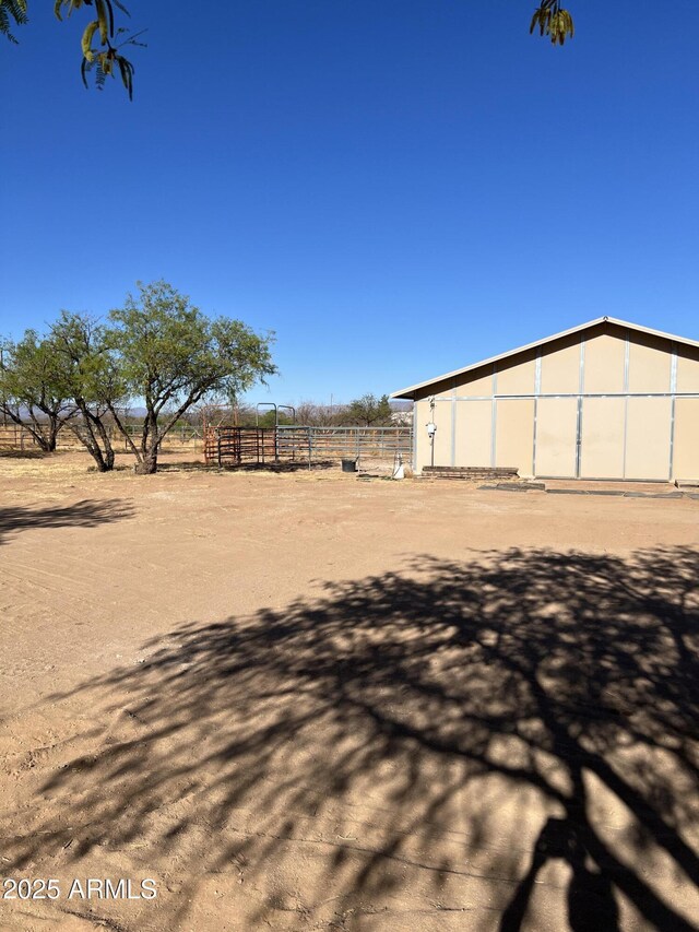 view of yard with a rural view and fence
