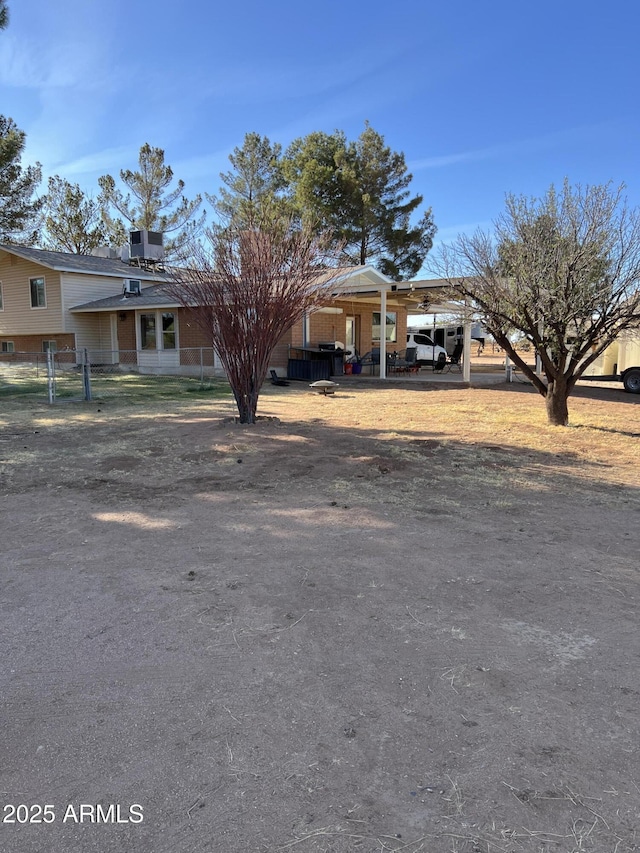 view of front of property featuring fence and a carport
