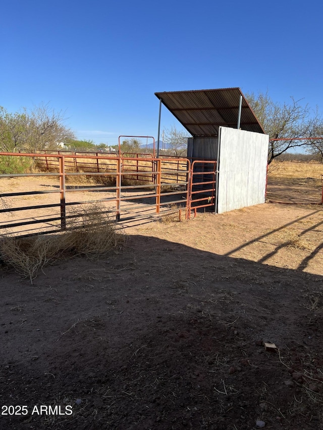 view of yard featuring an exterior structure, an outbuilding, and a rural view