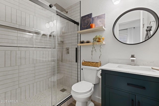 bathroom with toilet, a shower with shower door, and vanity