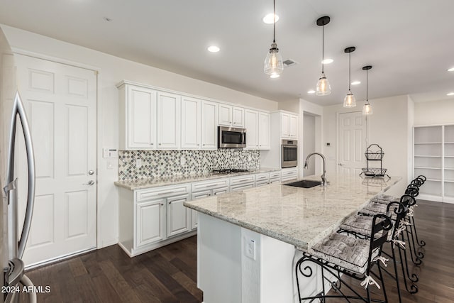 kitchen with white cabinetry, sink, a spacious island, hanging light fixtures, and stainless steel appliances