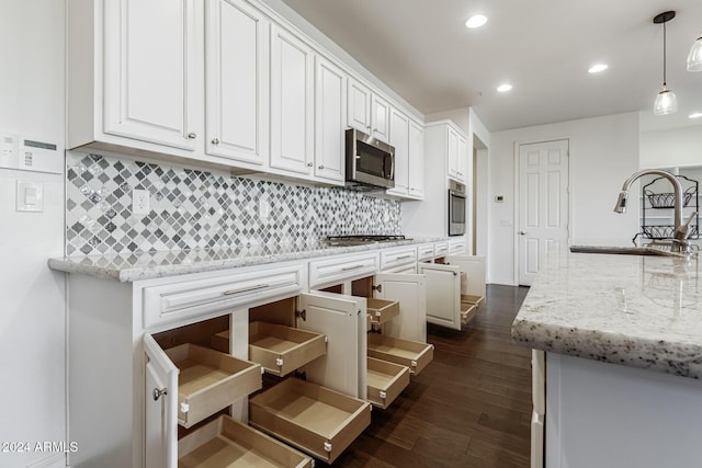 kitchen featuring stainless steel appliances, a sink, white cabinetry, decorative backsplash, and recessed lighting