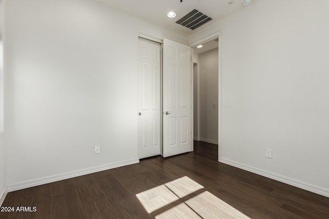 unfurnished bedroom featuring a closet and dark hardwood / wood-style floors