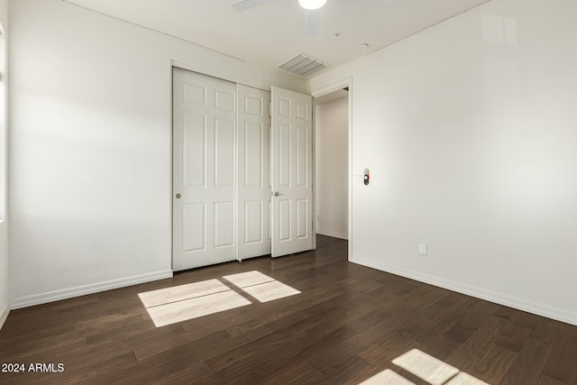 unfurnished bedroom with ceiling fan, a closet, and dark hardwood / wood-style floors