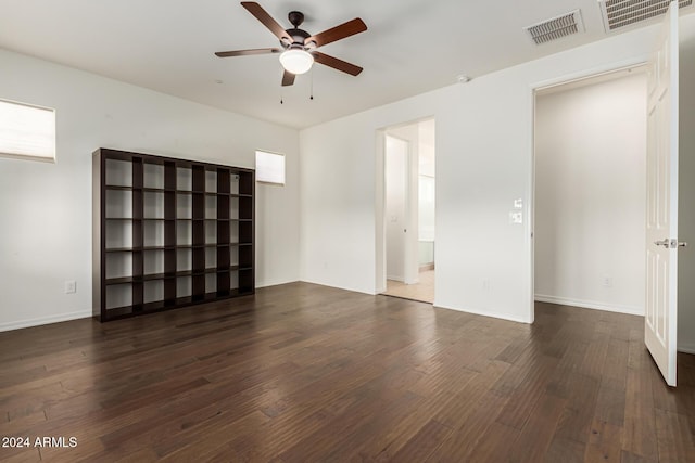 empty room with a ceiling fan, wood finished floors, and baseboards