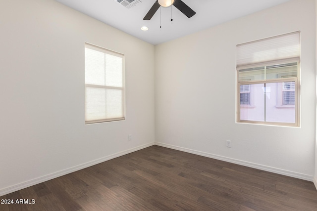 spare room with a ceiling fan, healthy amount of natural light, dark wood-style flooring, baseboards, and recessed lighting
